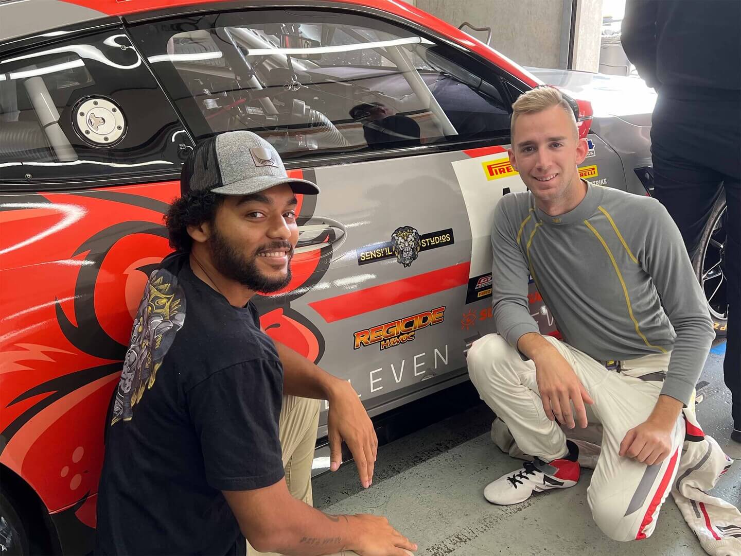 photo of Basi White & race car driver Colin Garrett showing Sensiil Studios' logo on Garrett's car at Indy